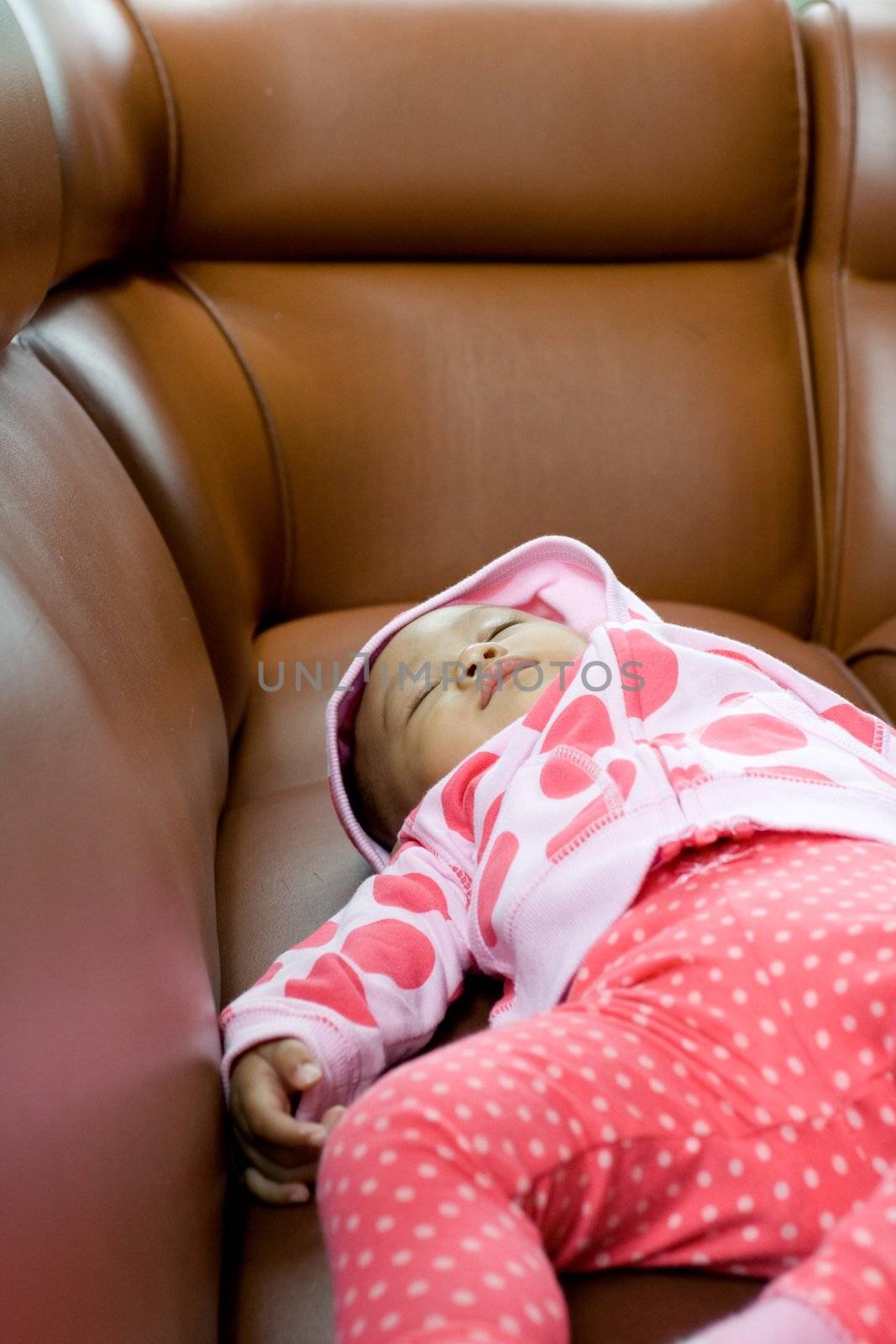 photo of a baby fall a sleep on the sofa at a restaurant