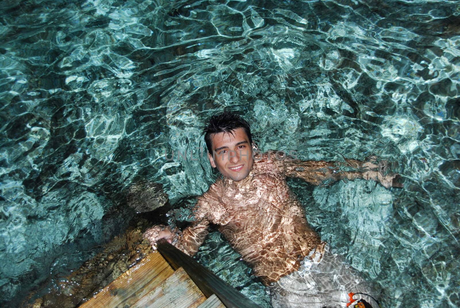 young adult smiling on translucid water in a Maldivian Island (night shoot)