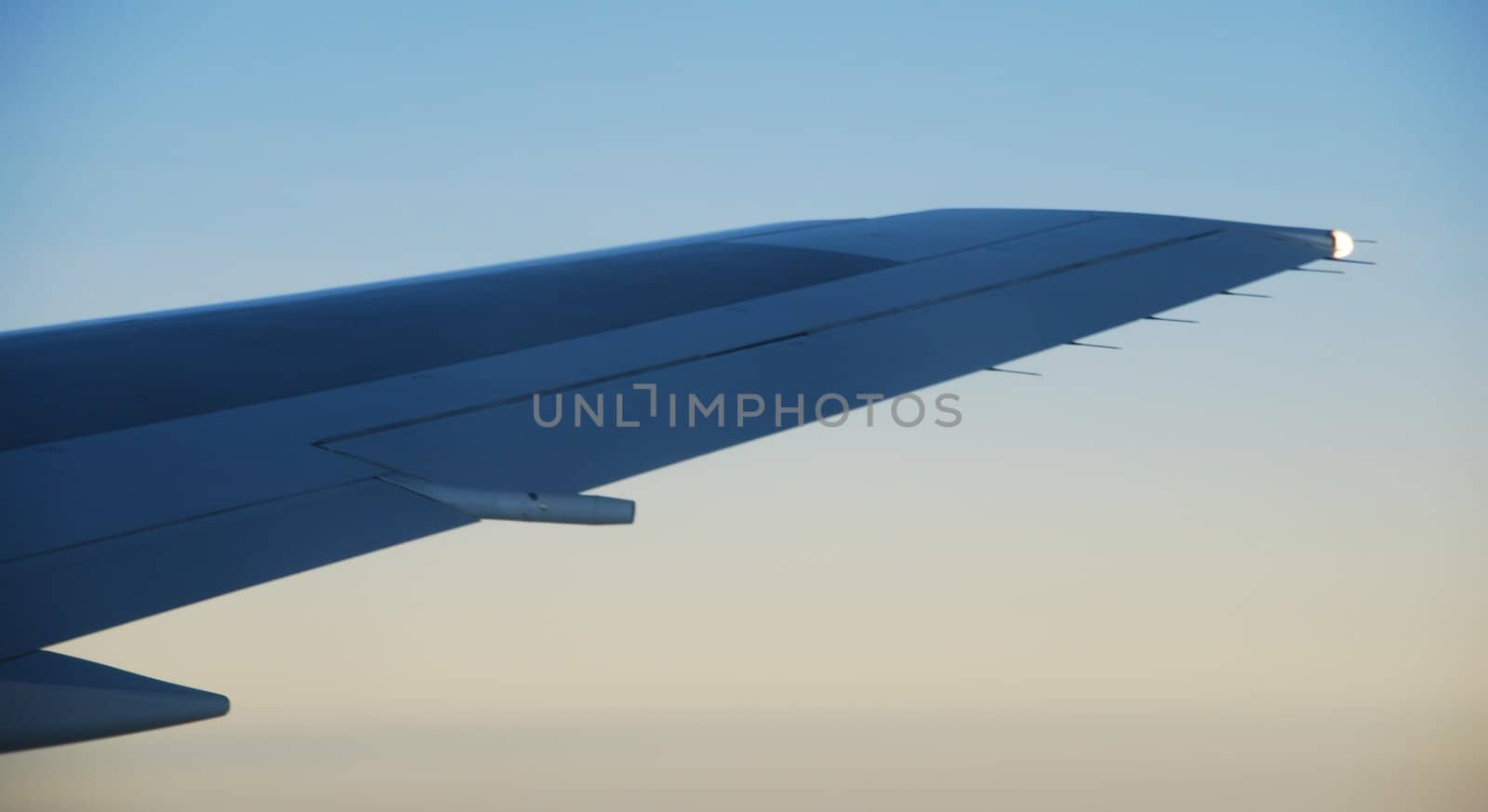 photo of a airplane wing at sunset