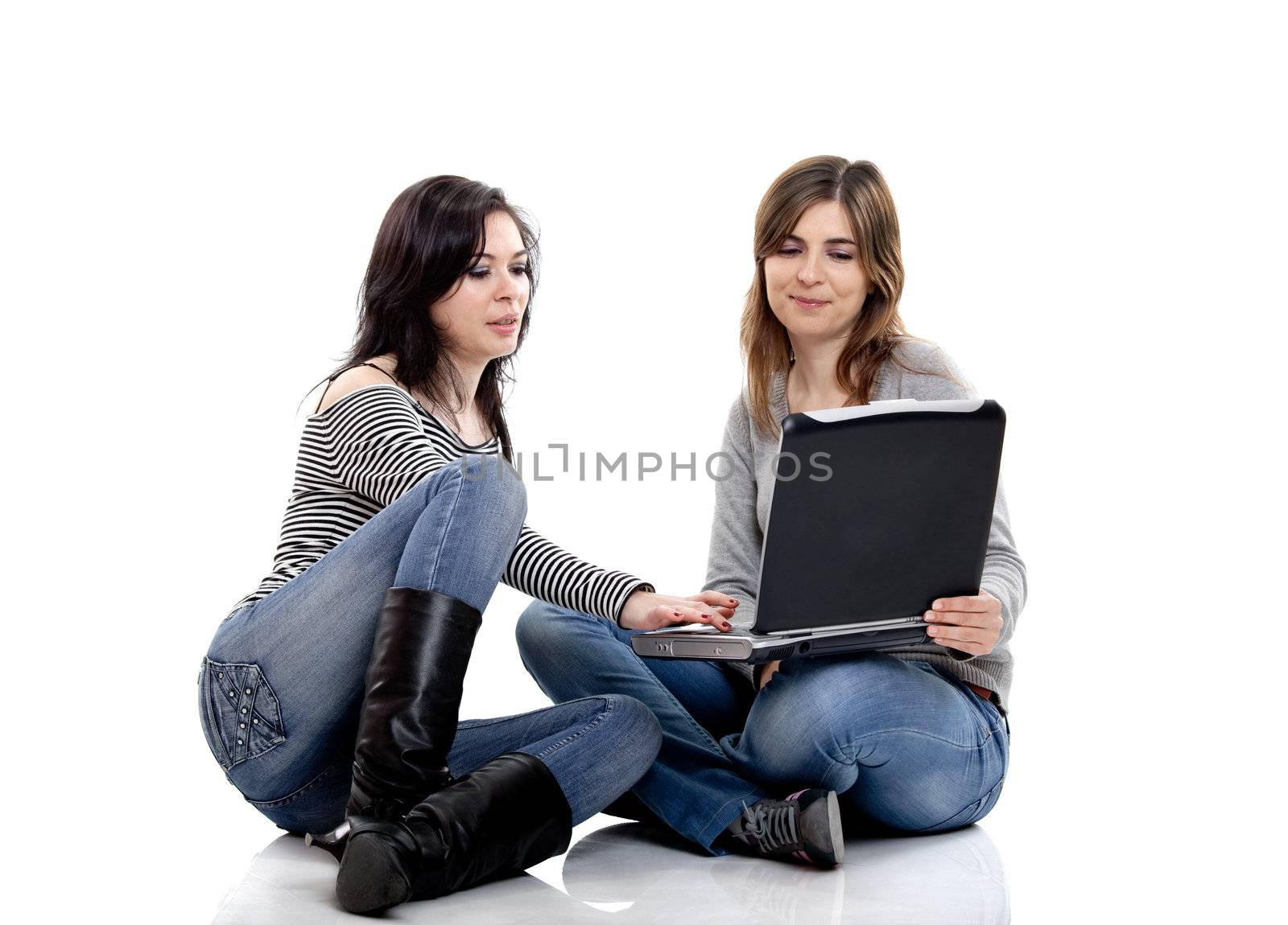 Two female young students working with a laptop
