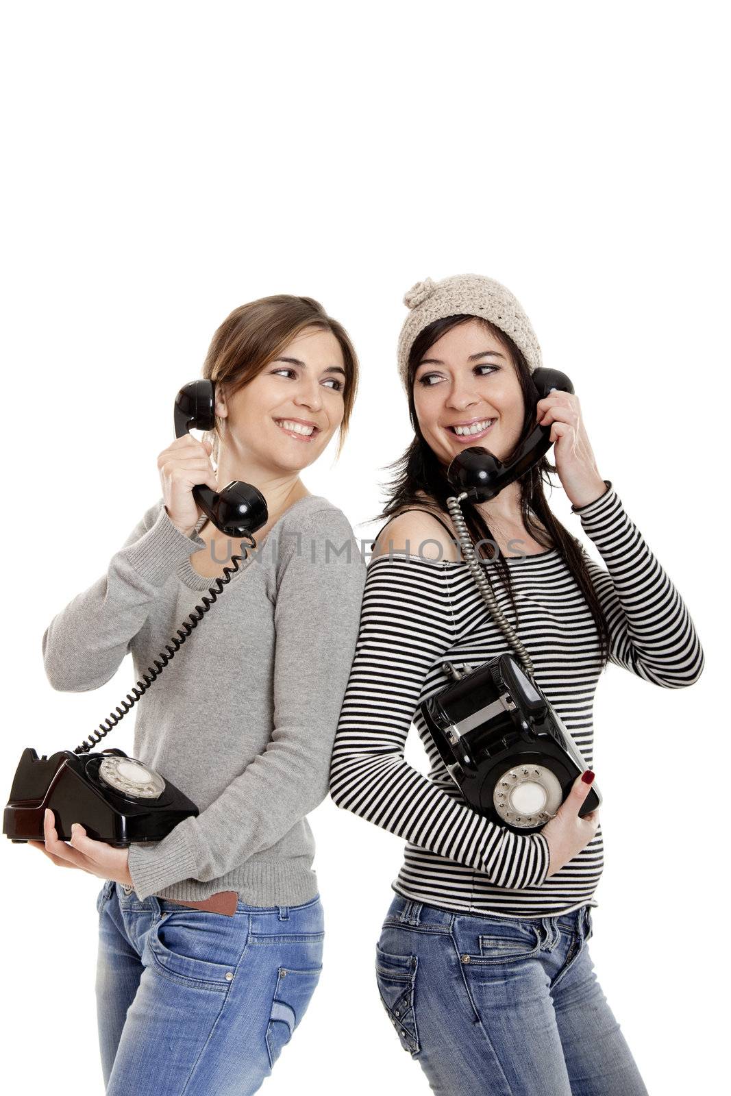 Two young women talking with old telephones - Isolated on white