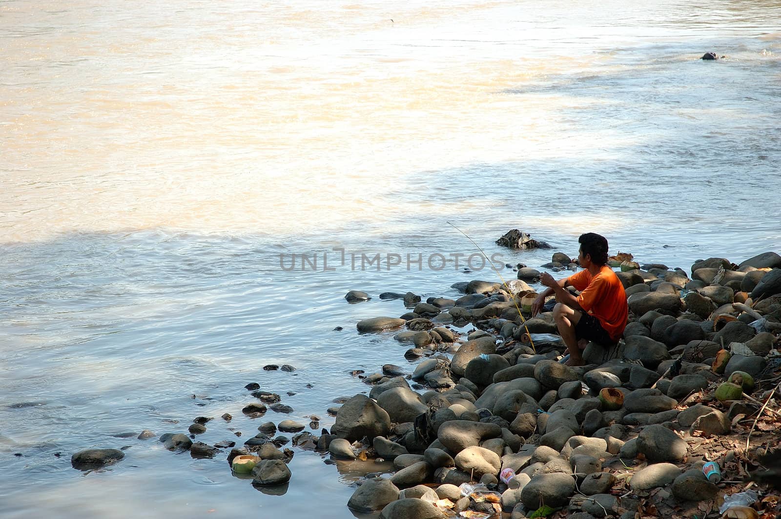 man doing for fishing beside the river