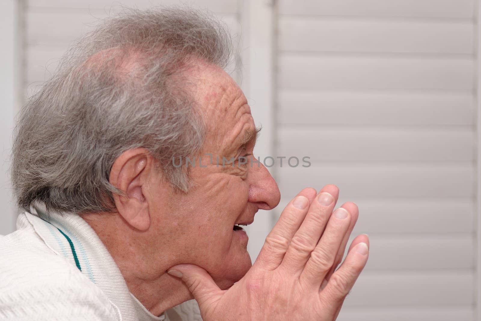 Smiling elderly man resting his head on hands profile closeup
