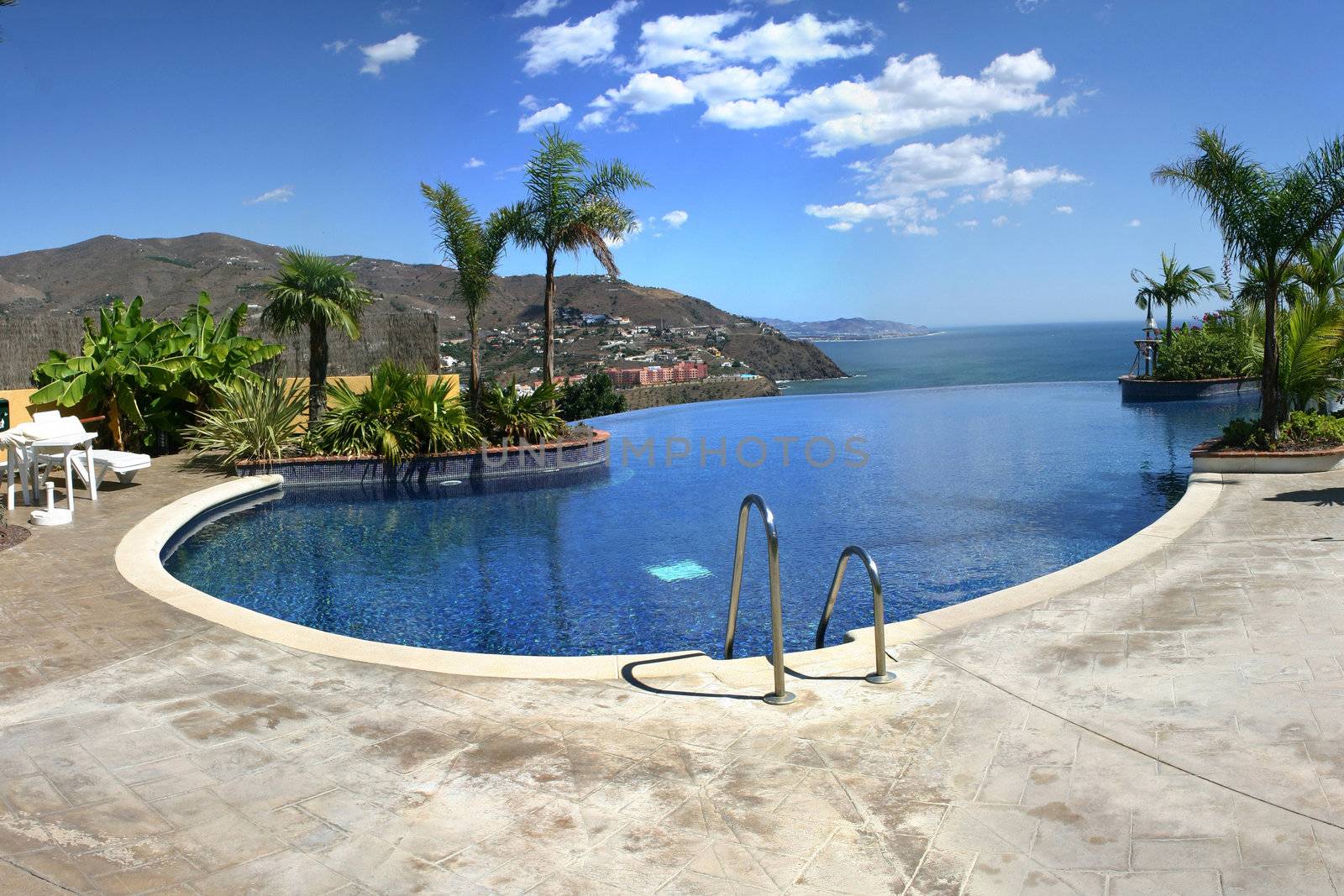 Large image of an infinity pool overlooking the sea and mountains.