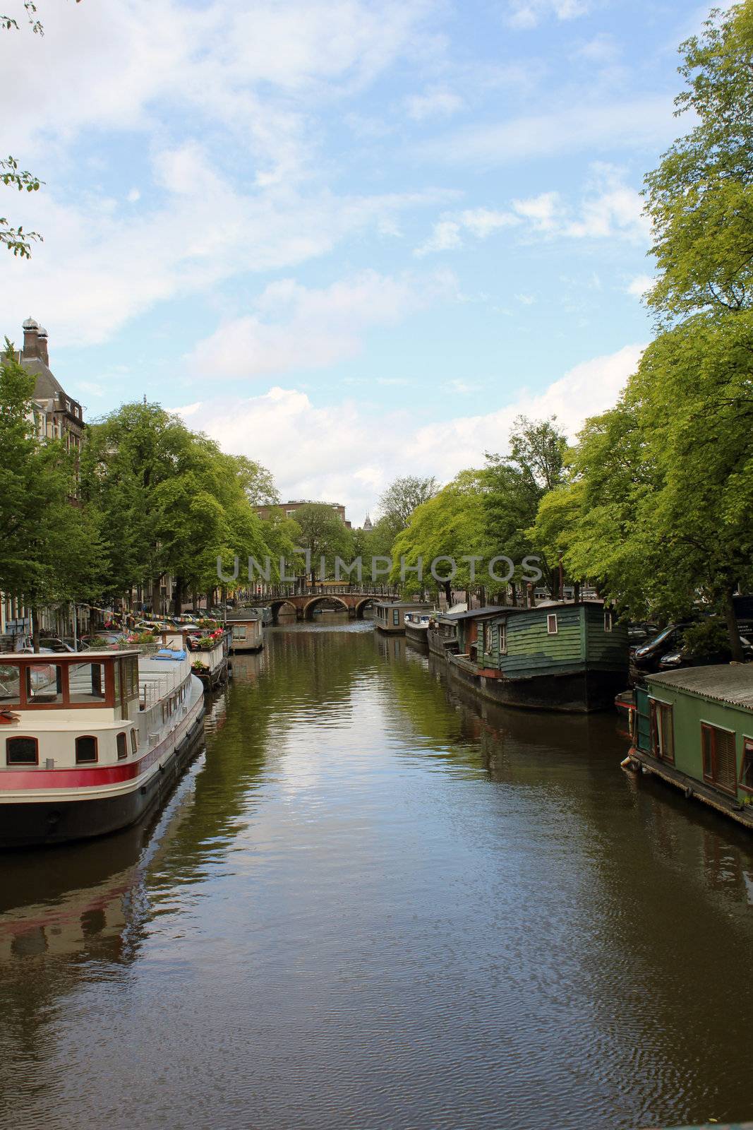 A typical Amsterdam canal with boat houses and a brige