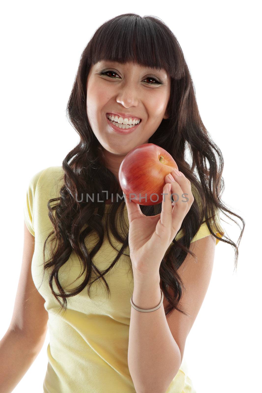 A very happy vivacious young woman holding a delicious healthy fresh red apple.  