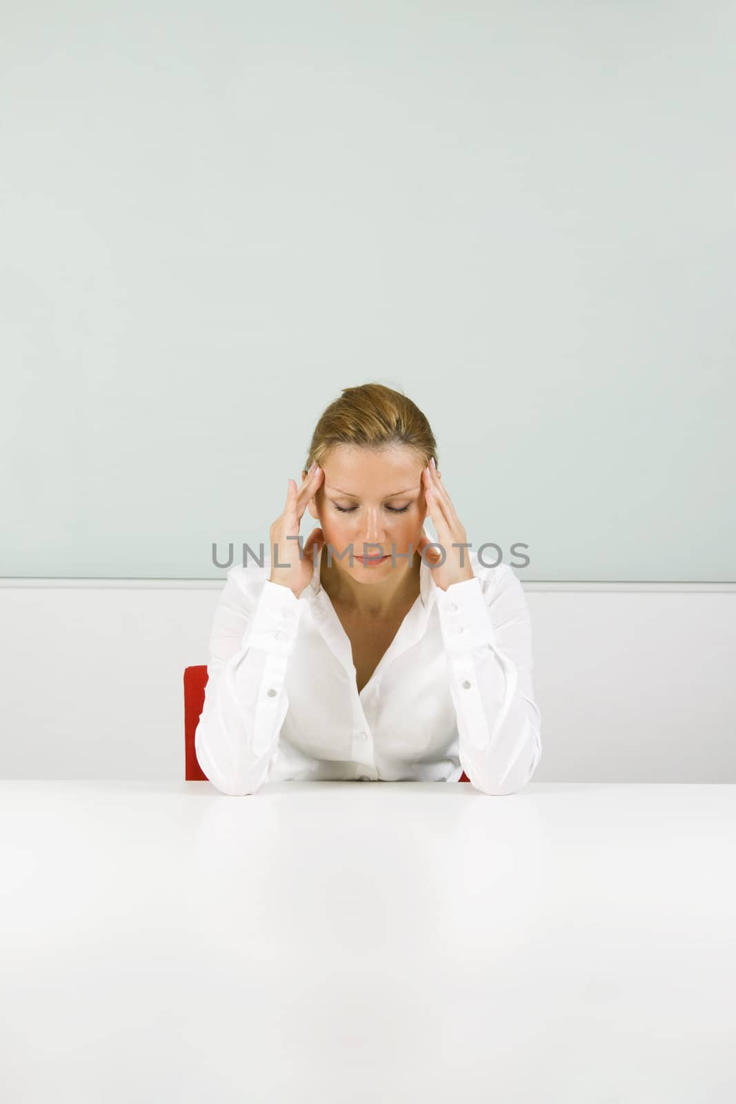 Young blond businesswoman in stress, with headache