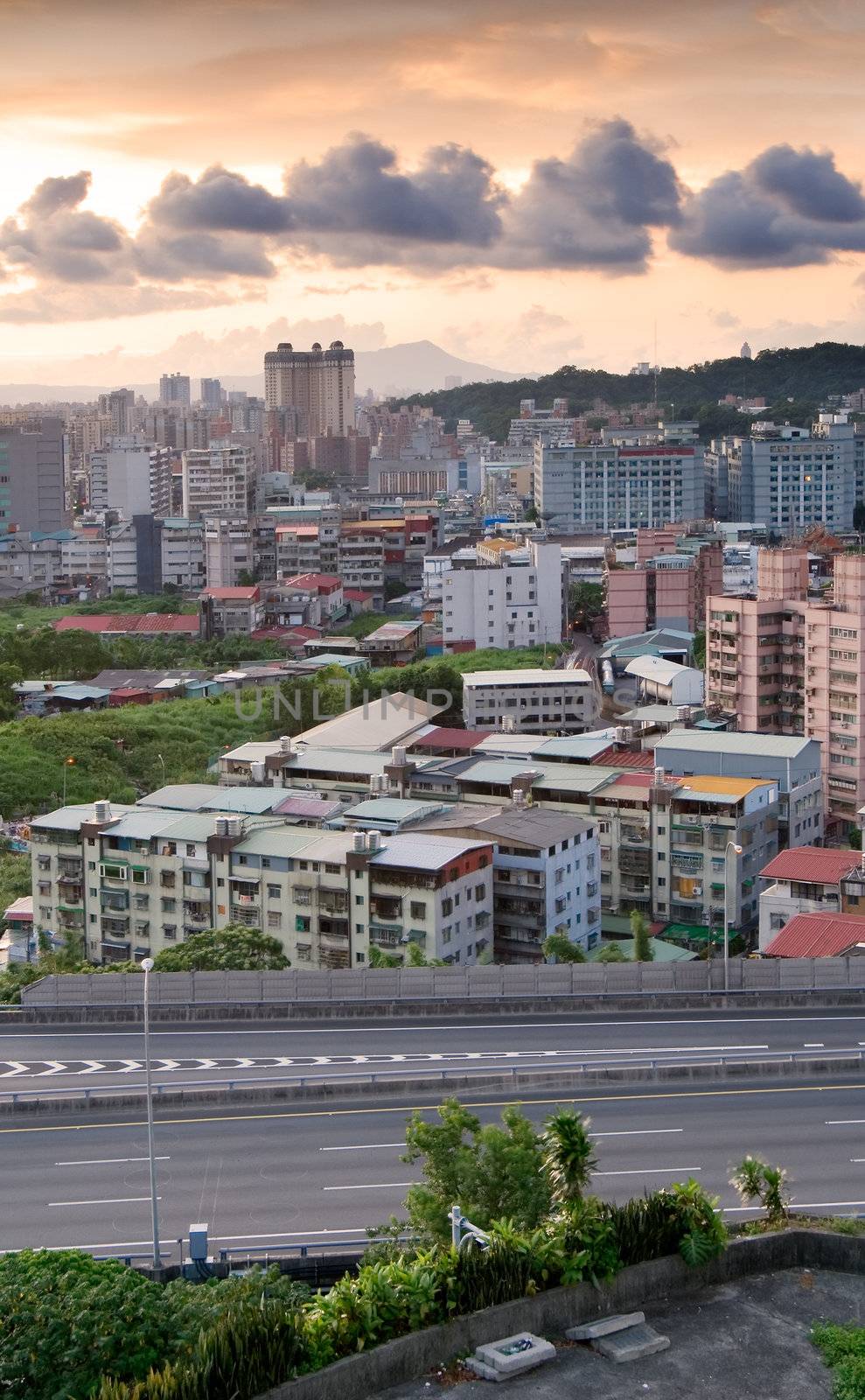 It is a cityscape photo of apartments and highway.