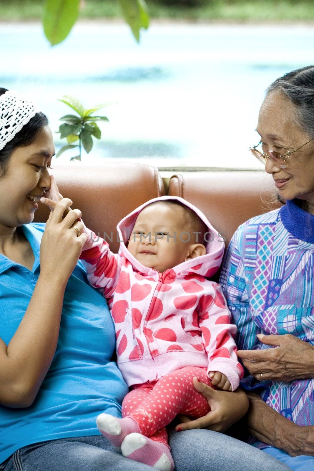 photo of 3 generation woman: a baby, mom and grandma having a good time together - happy family