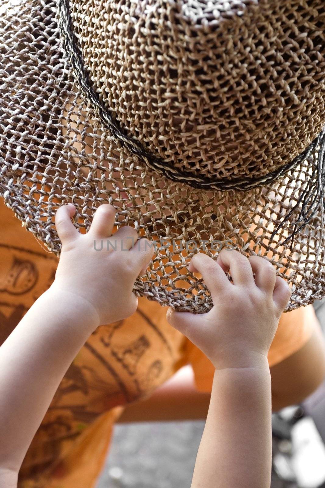 photo of a baby's hand grabbing a girl's hat - achievement
