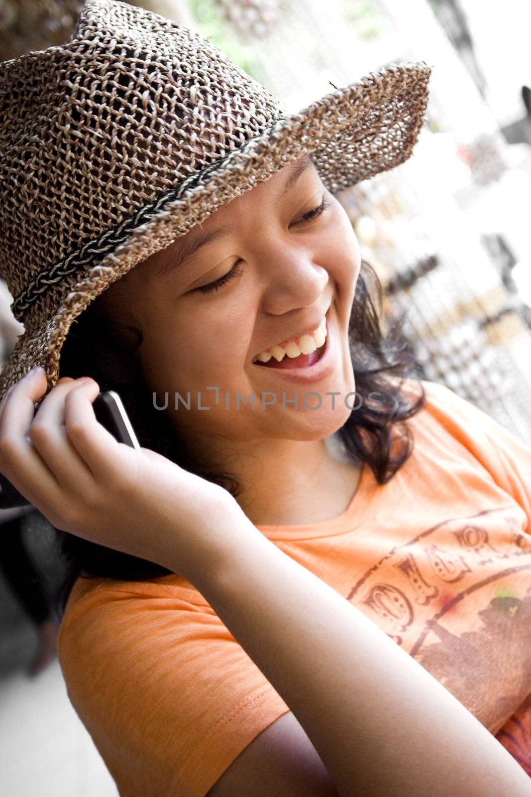 modern lifestyle portrait of female asian teen seems to enjoy her phone call conversation with friends