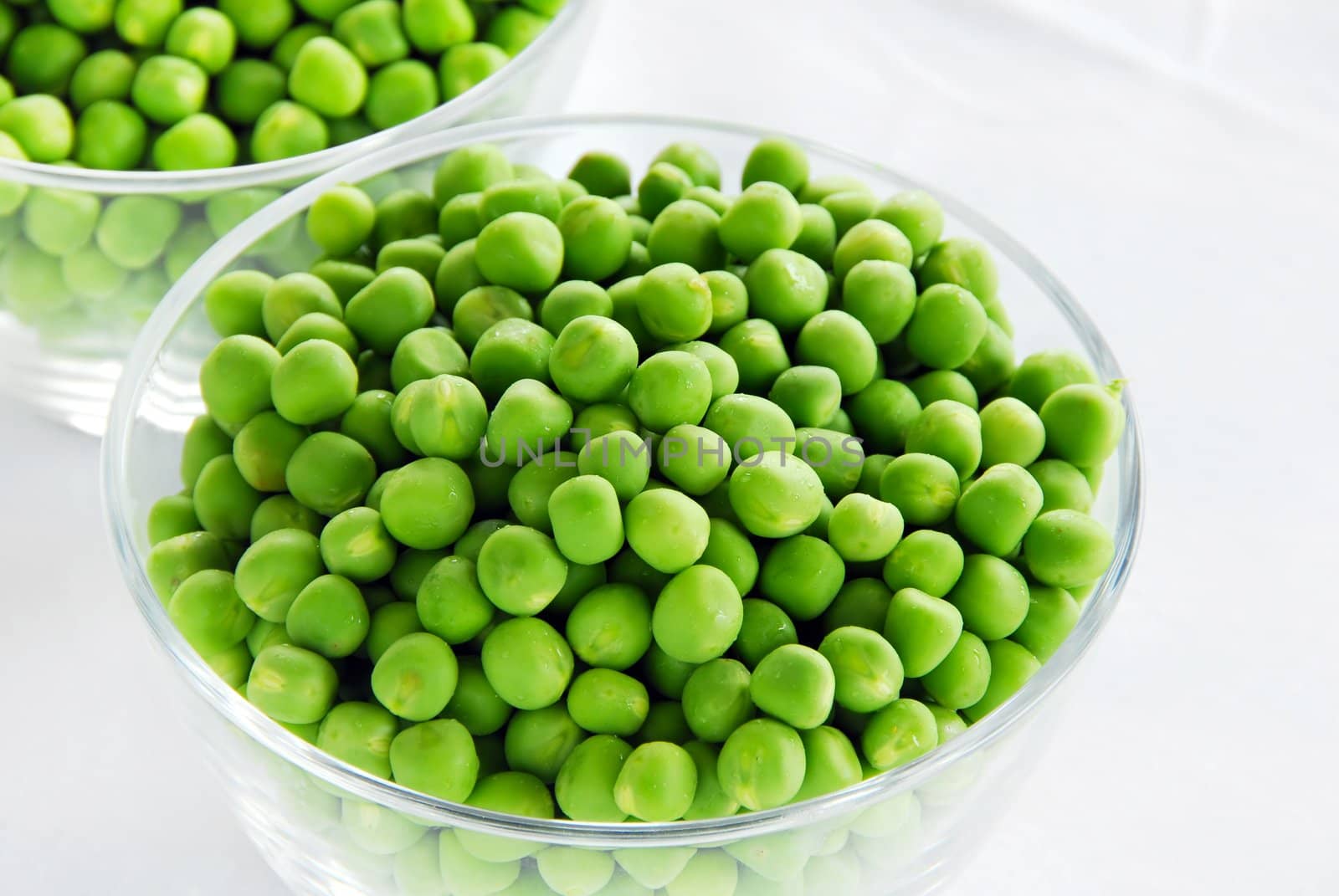 Young fresh green spring peas in glass bowls
