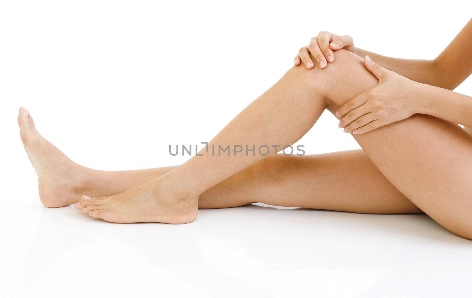 Woman holding on sore knee with white background.