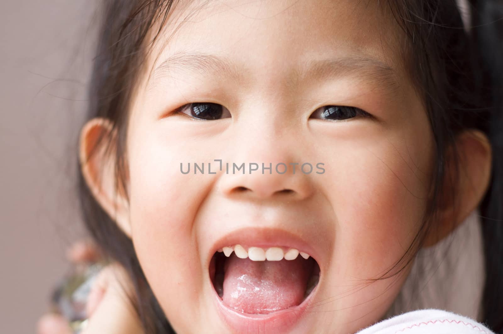 Close-up shot of a young Asian girl with smile on her face.