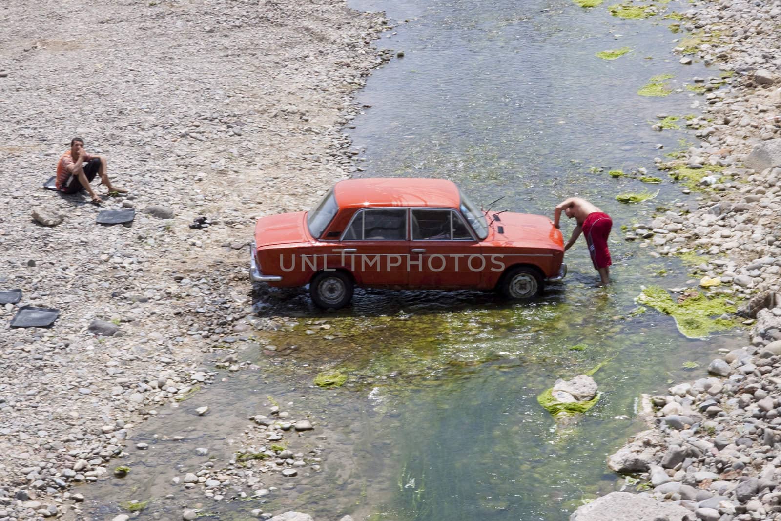 Washing car in river by parys