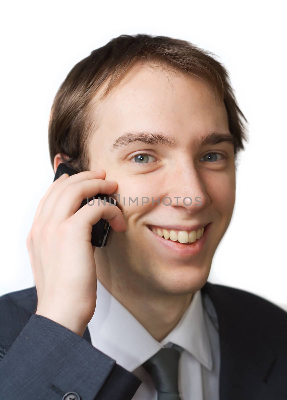 Young professional smiles while on the phone, isolated over white