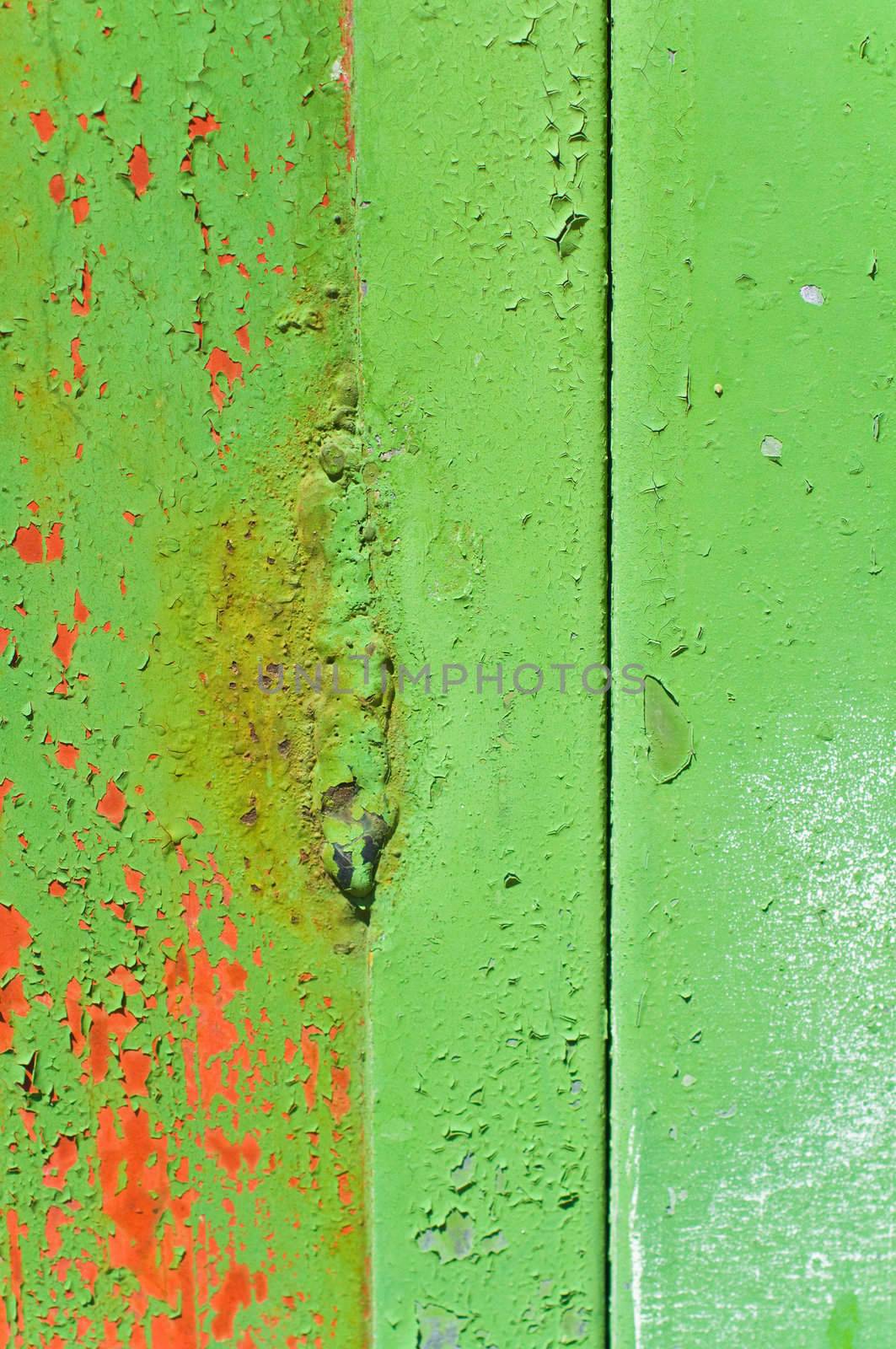 Close up shot of a metal door with green peeling paint
