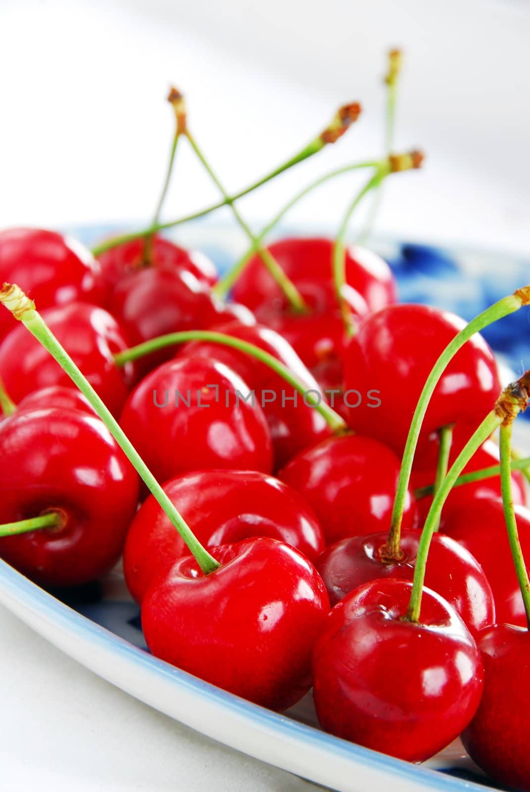 appetizing red fresh ripe cherries on blue plate