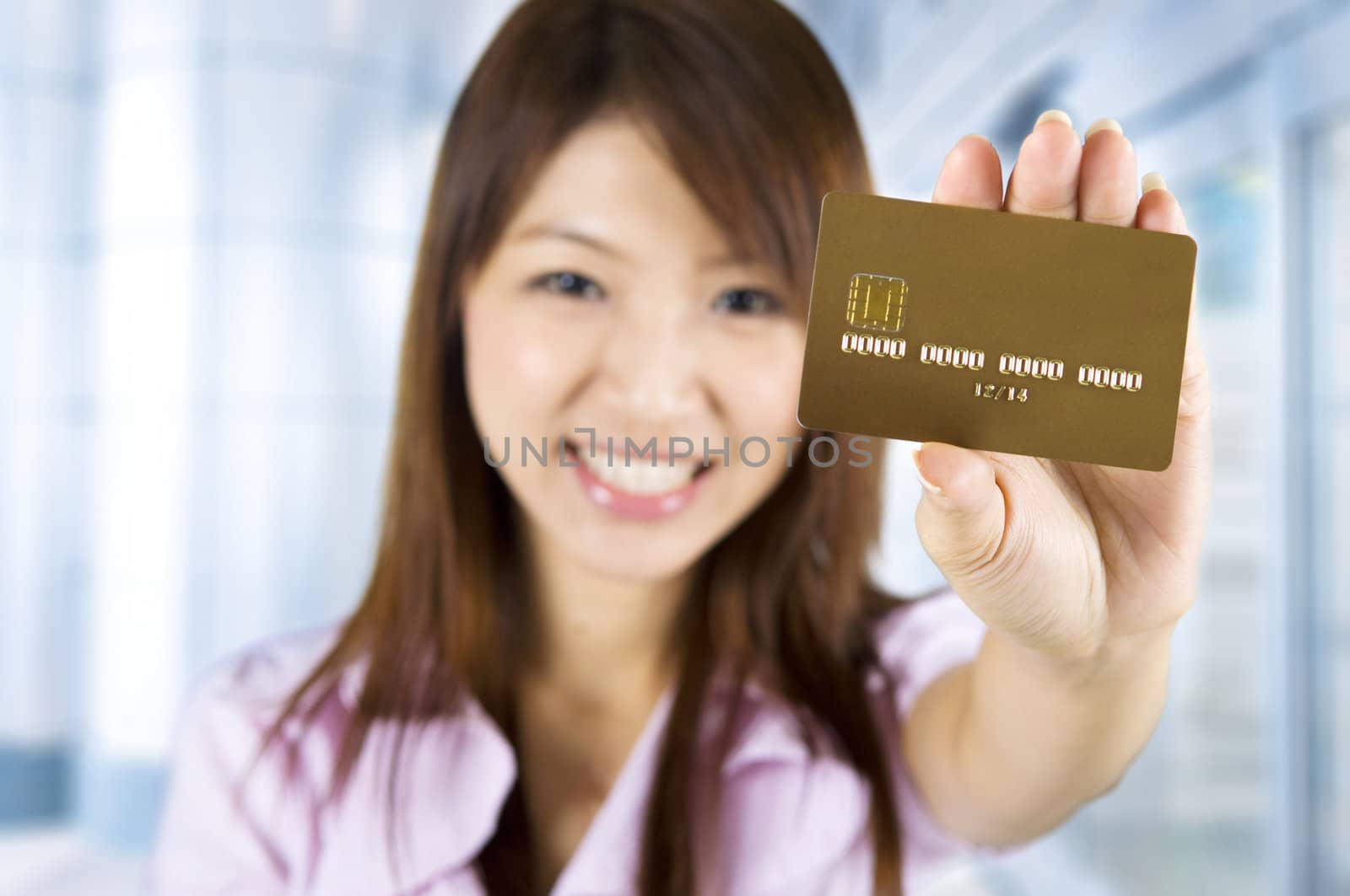 Asian woman holding a credit card, focus on the card. Card number and expiry date created by my own.
