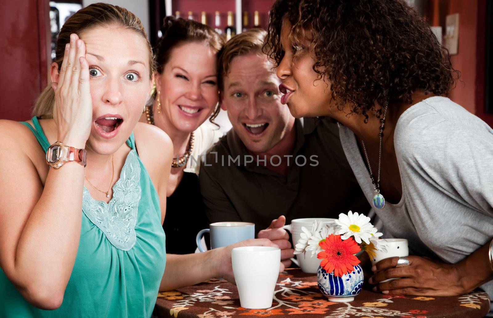 Four adult gossiping friends meeting in a coffee house