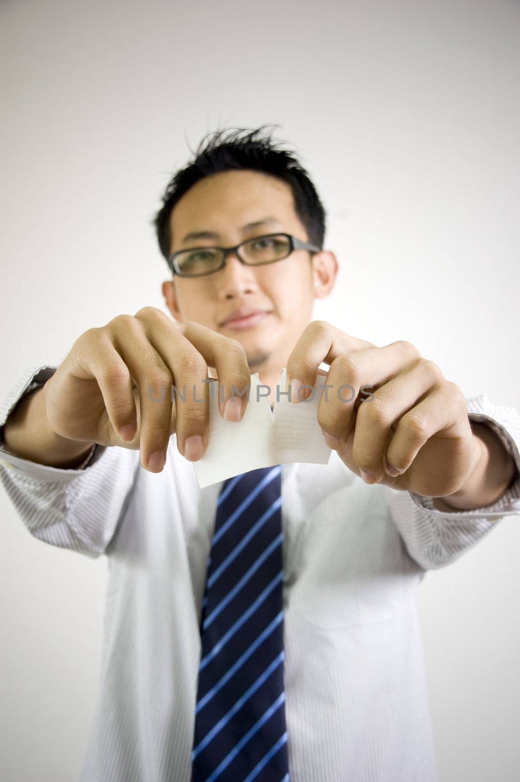 Asian businessman tear to pieces sheets of card 

