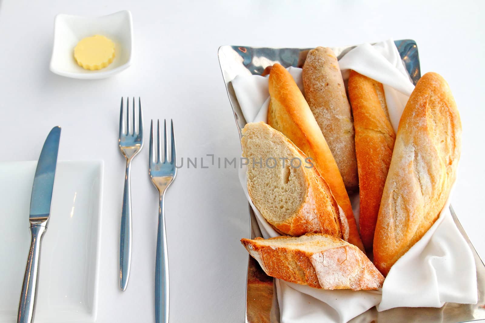 Sliced baguette with butter and knife