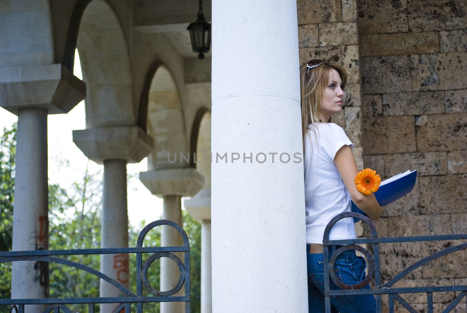 beautiful young woman with books and flower outdoor