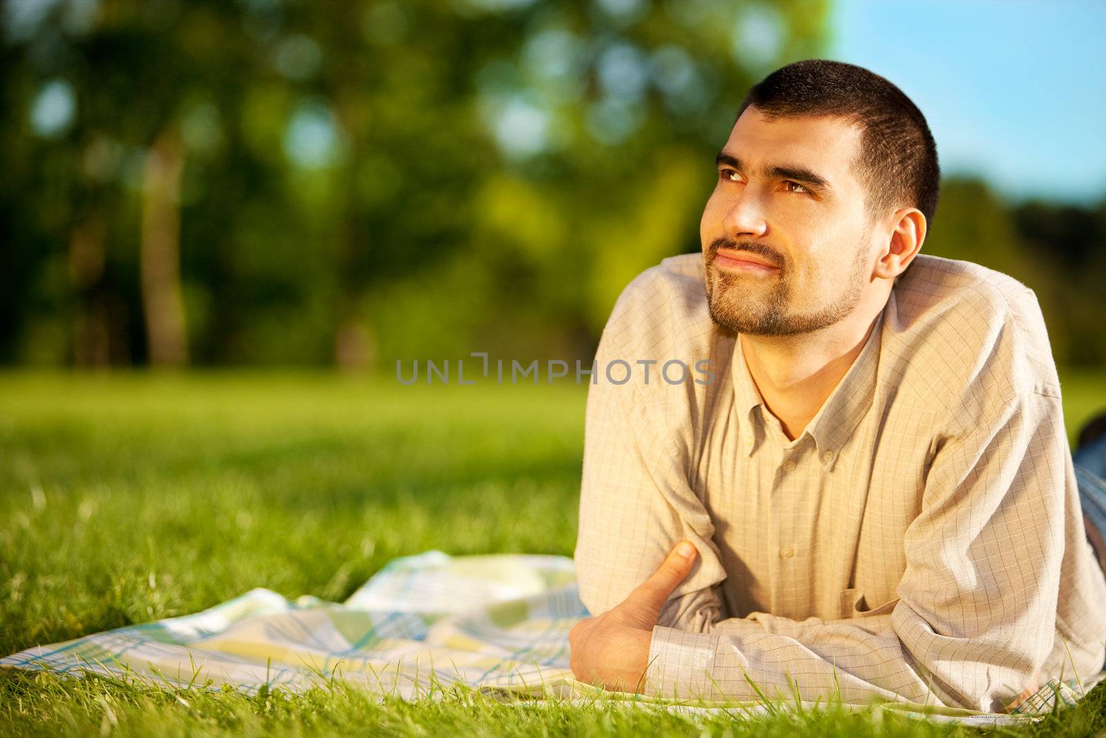 Young attractive man dreaming on a meadow