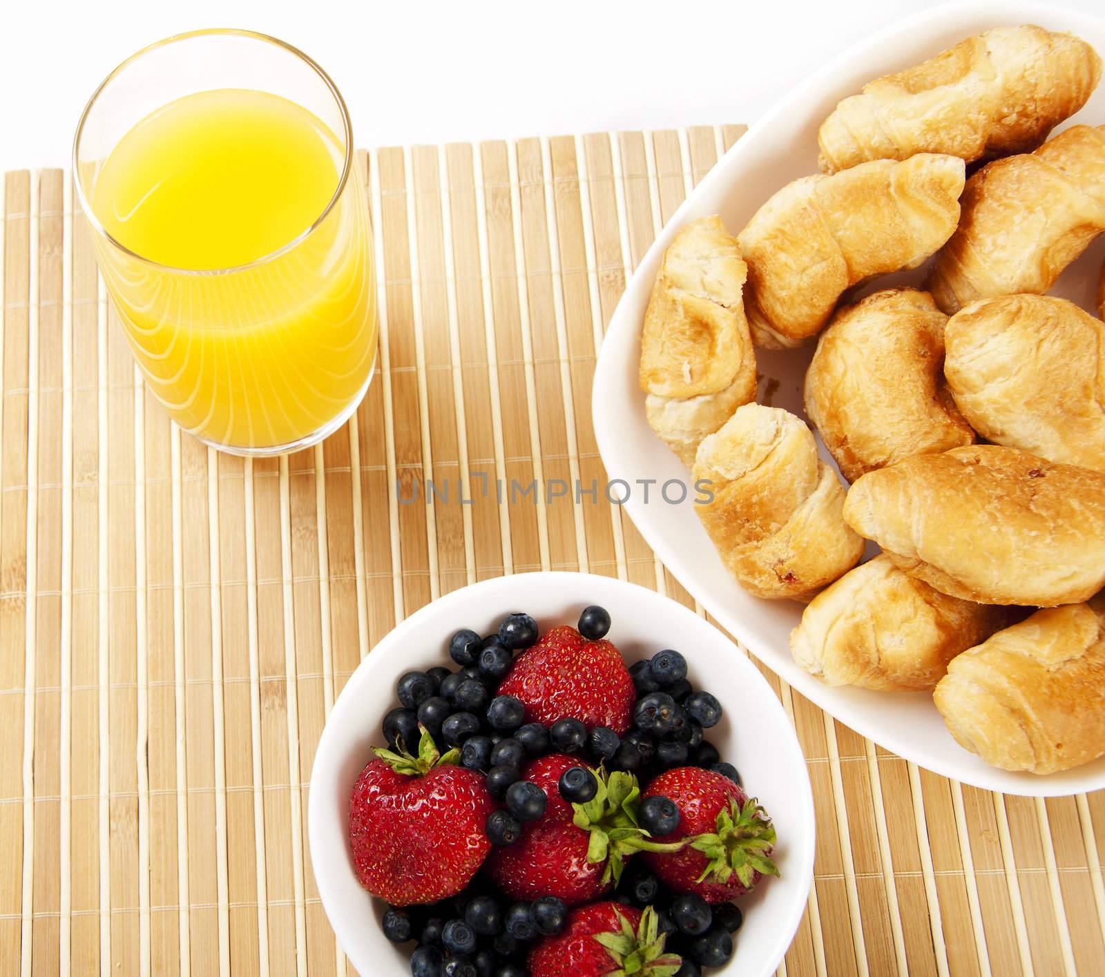 light Breakfast: orange juice, croissants and Berries on a table