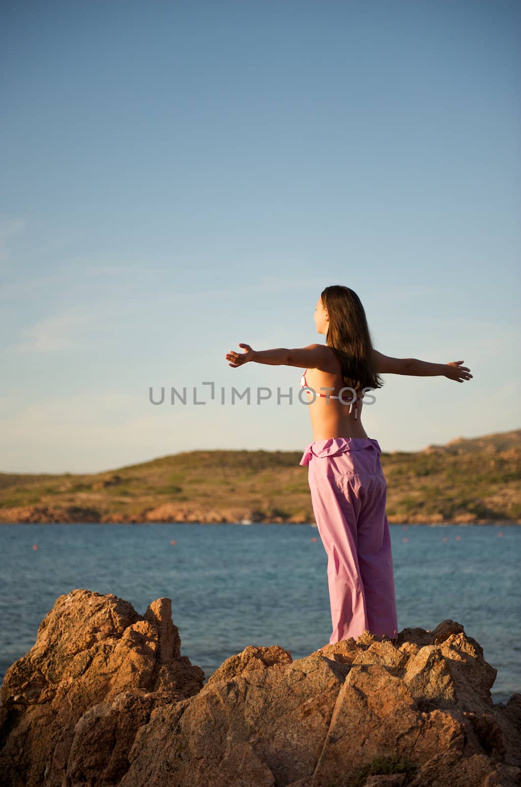 Woman relaxing on the rock with a sea view