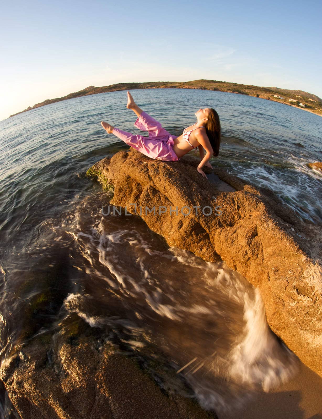 Woman relaxing on the rock with a sea view