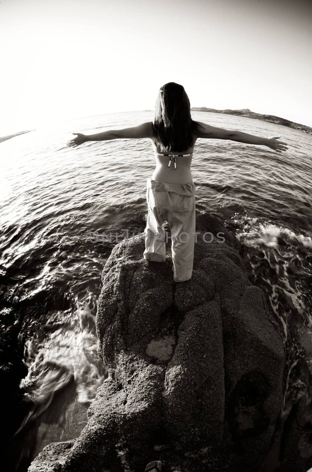 Woman relaxing on the rock with a sea view