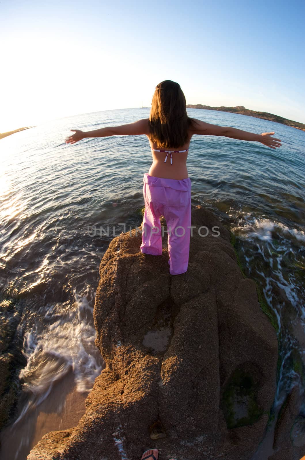 Woman relaxing on the rock with a sea view