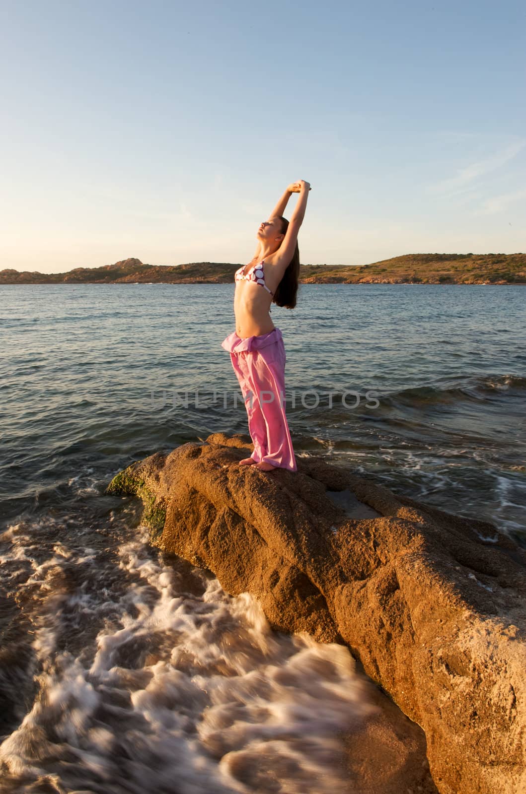 Woman relaxing on the rock with a sea view