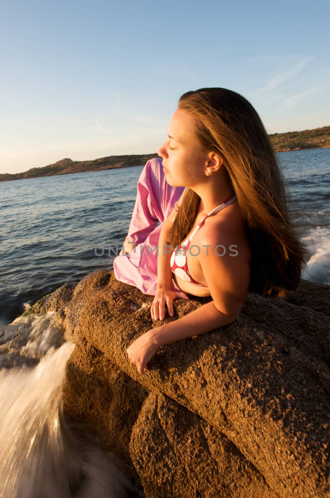 Woman relaxing on the rock with a sea view