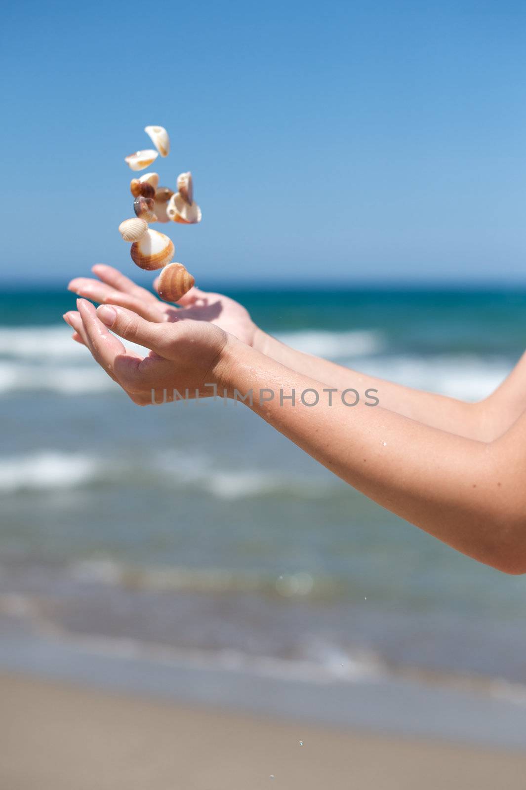 Woman playing with some shells on the beach