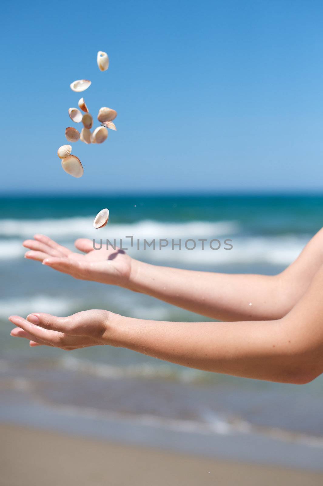 Woman playing with some shells on the beach