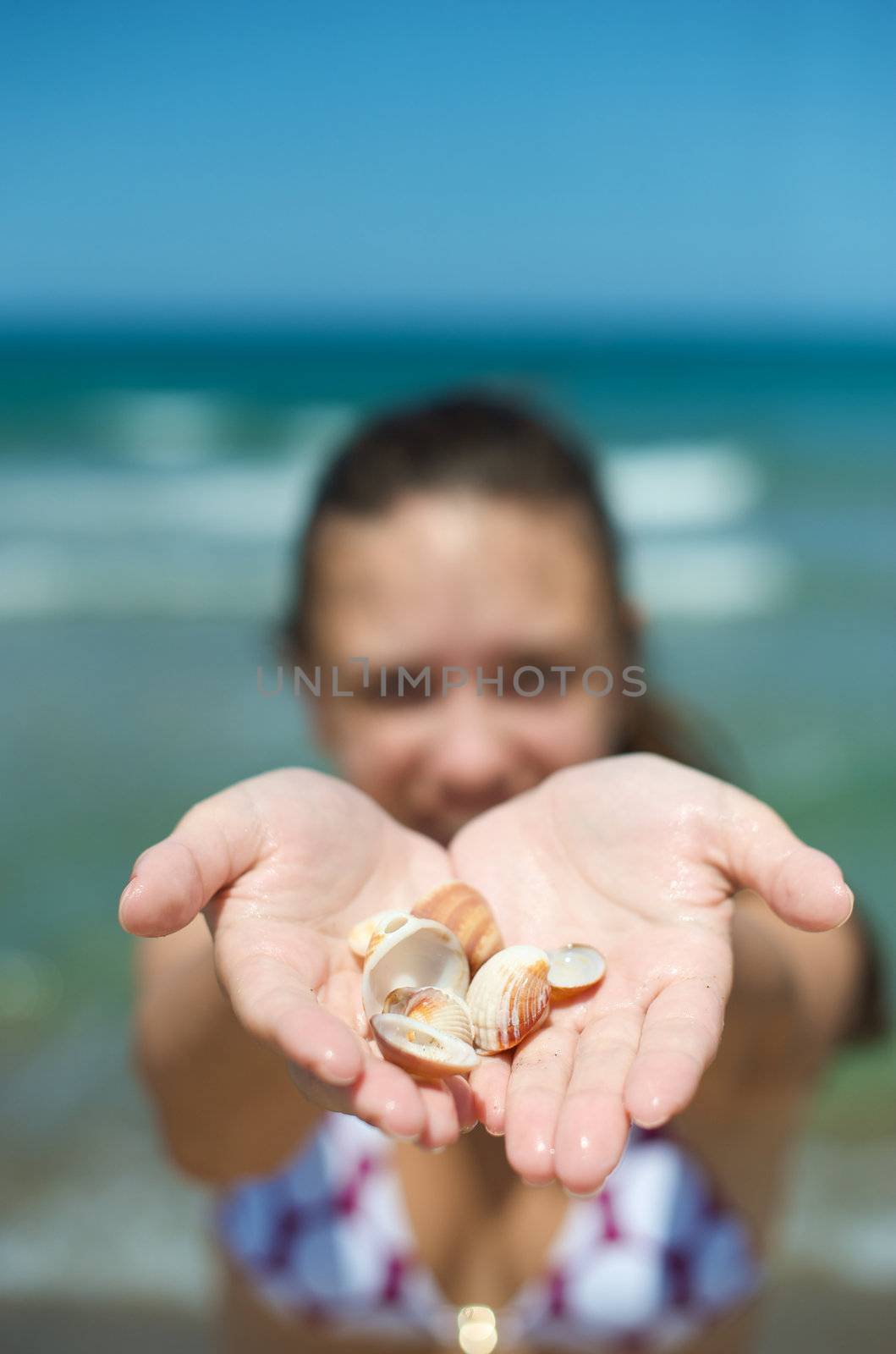 Woman playing with some shells on the beach