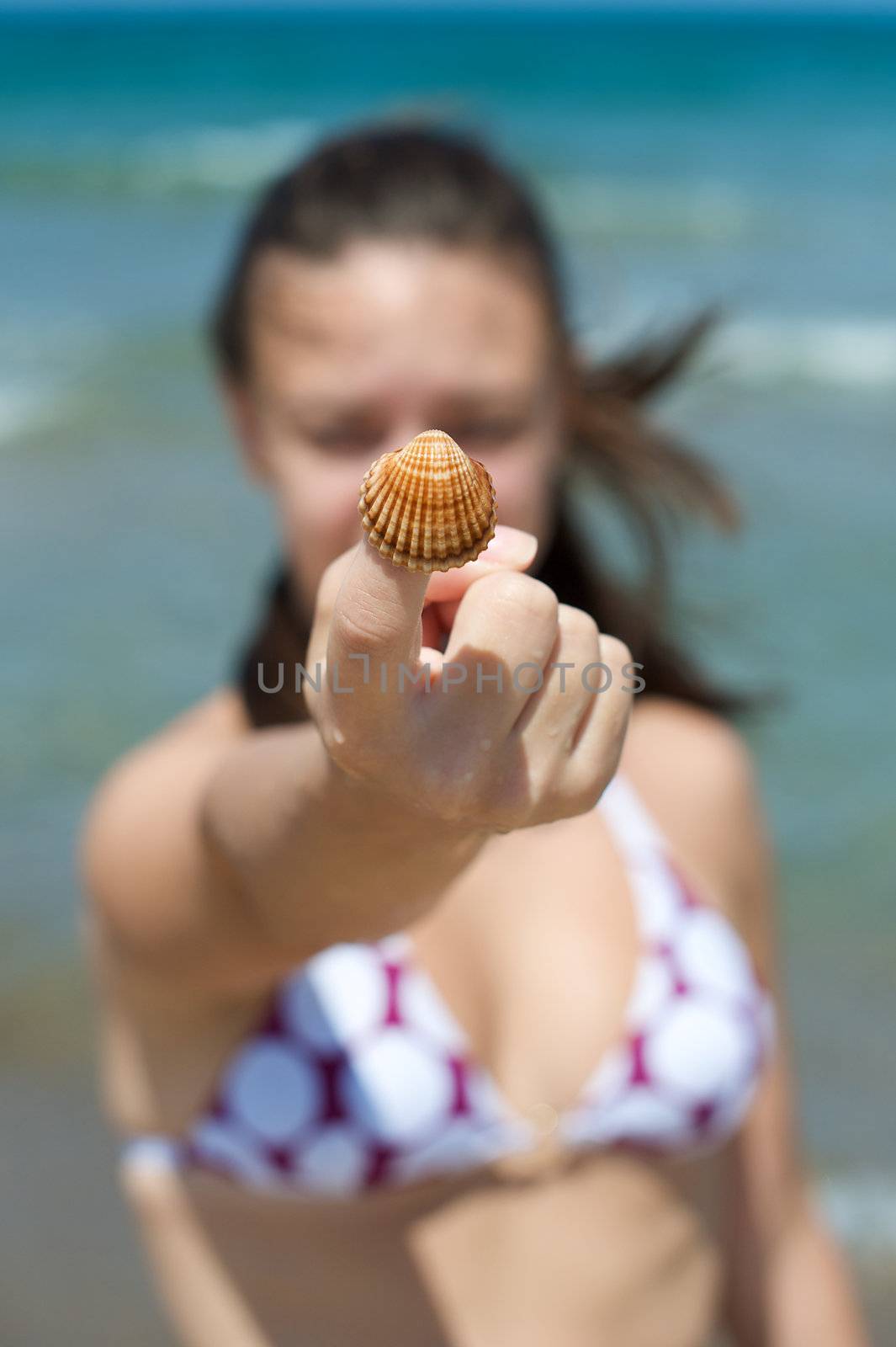 Woman playing with some shells on the beach