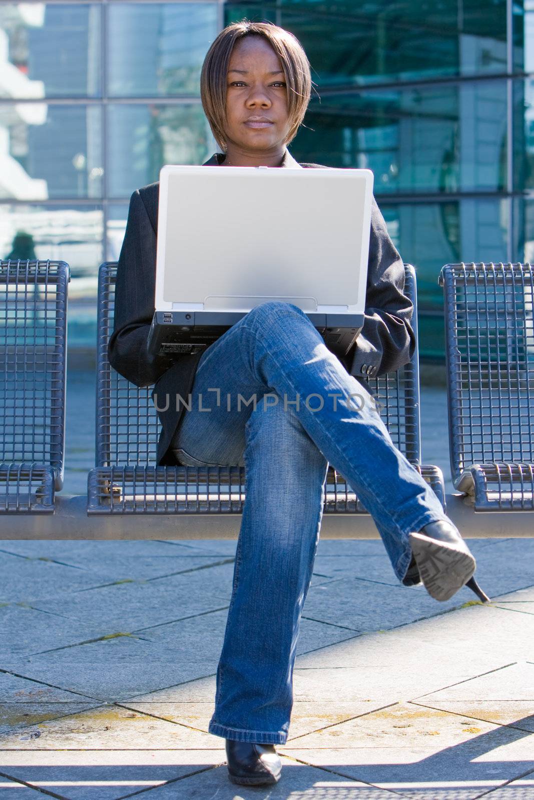 African american business woman with a computer notebook browsing outside an office building