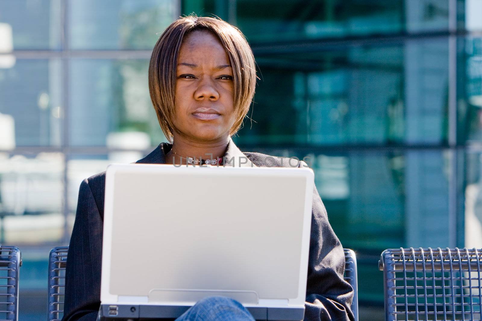 African american business woman with a computer notebook browsing outside an office building