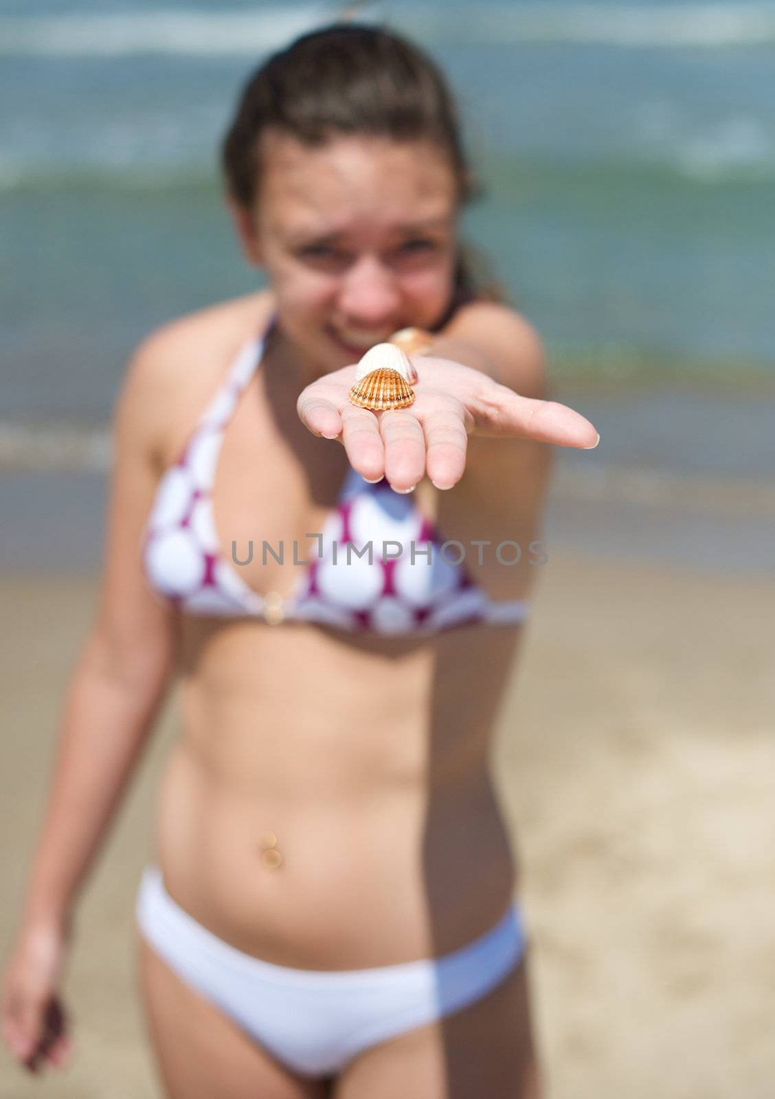 Woman playing with some shells on the beach