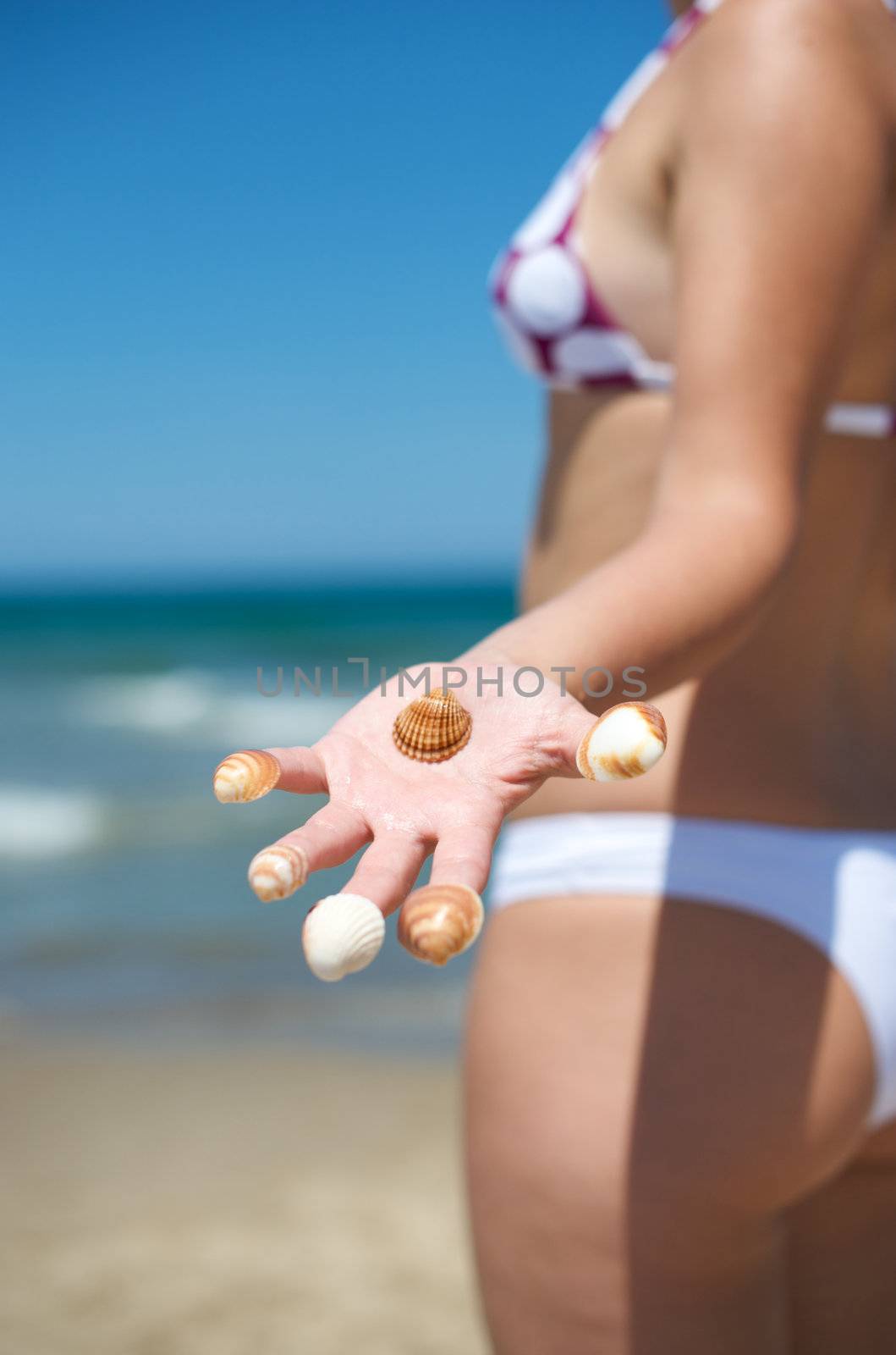 Woman playing with some shells on the beach