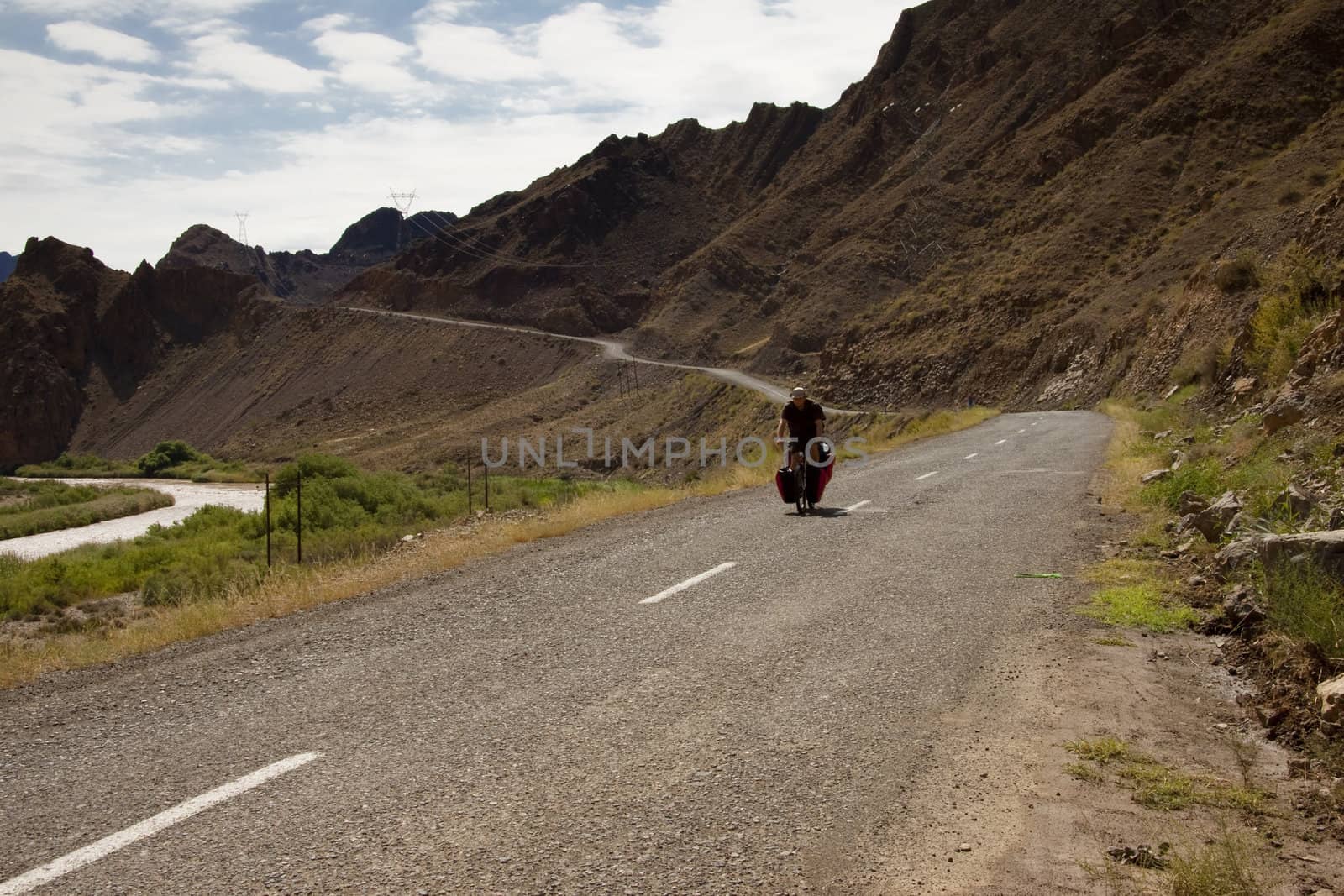 Man travelling by bicycles in Iran. Aras river and mountain