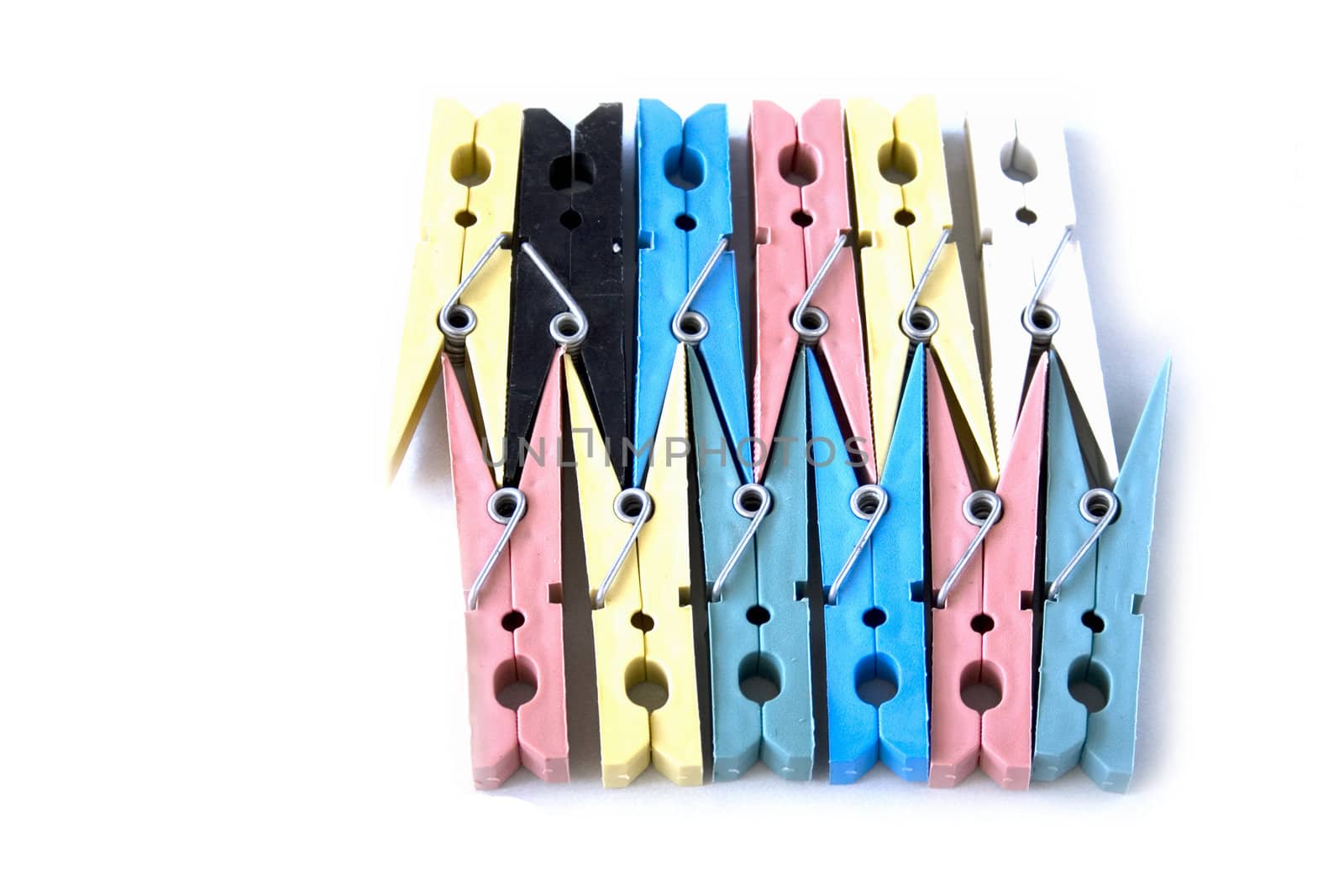 colored laundry pins on white background
