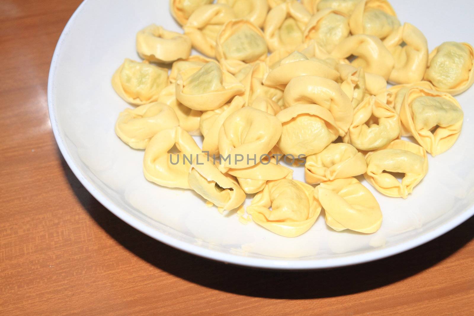 Tortellini with meat in a white dish 