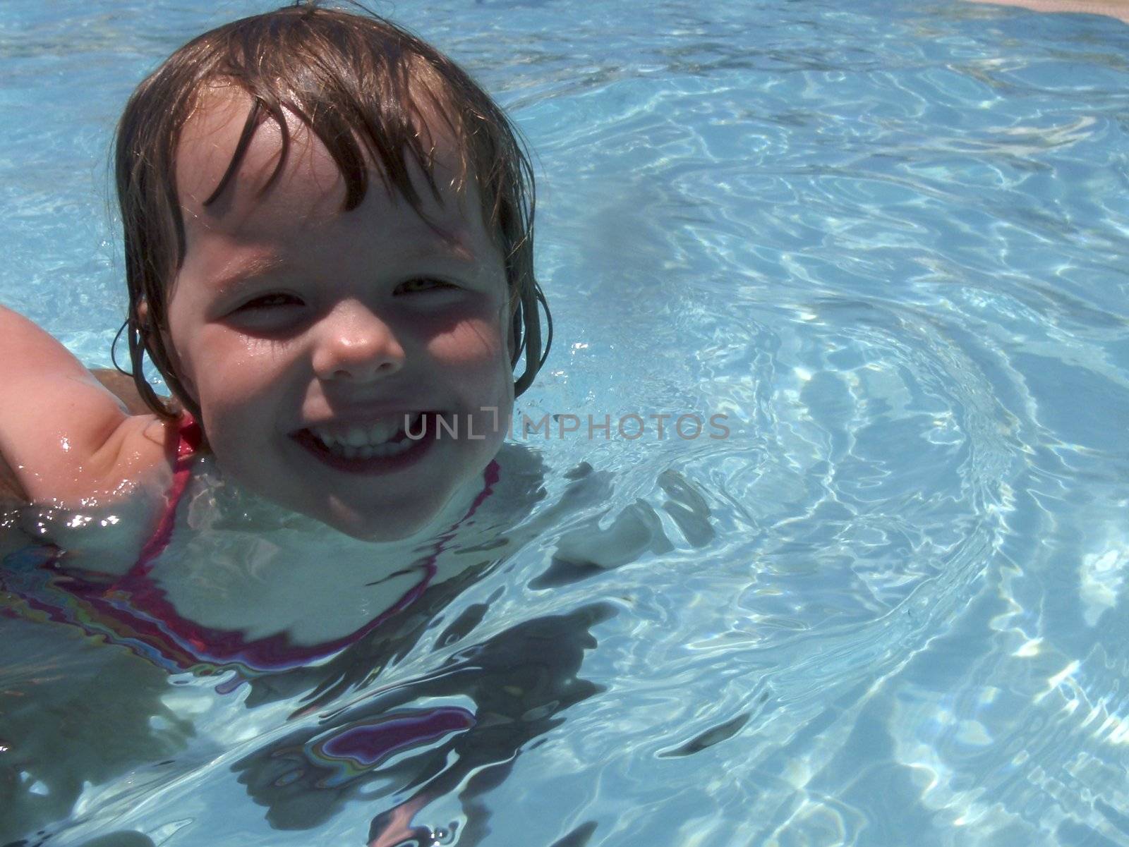 Little girl playing at neighborhood pool