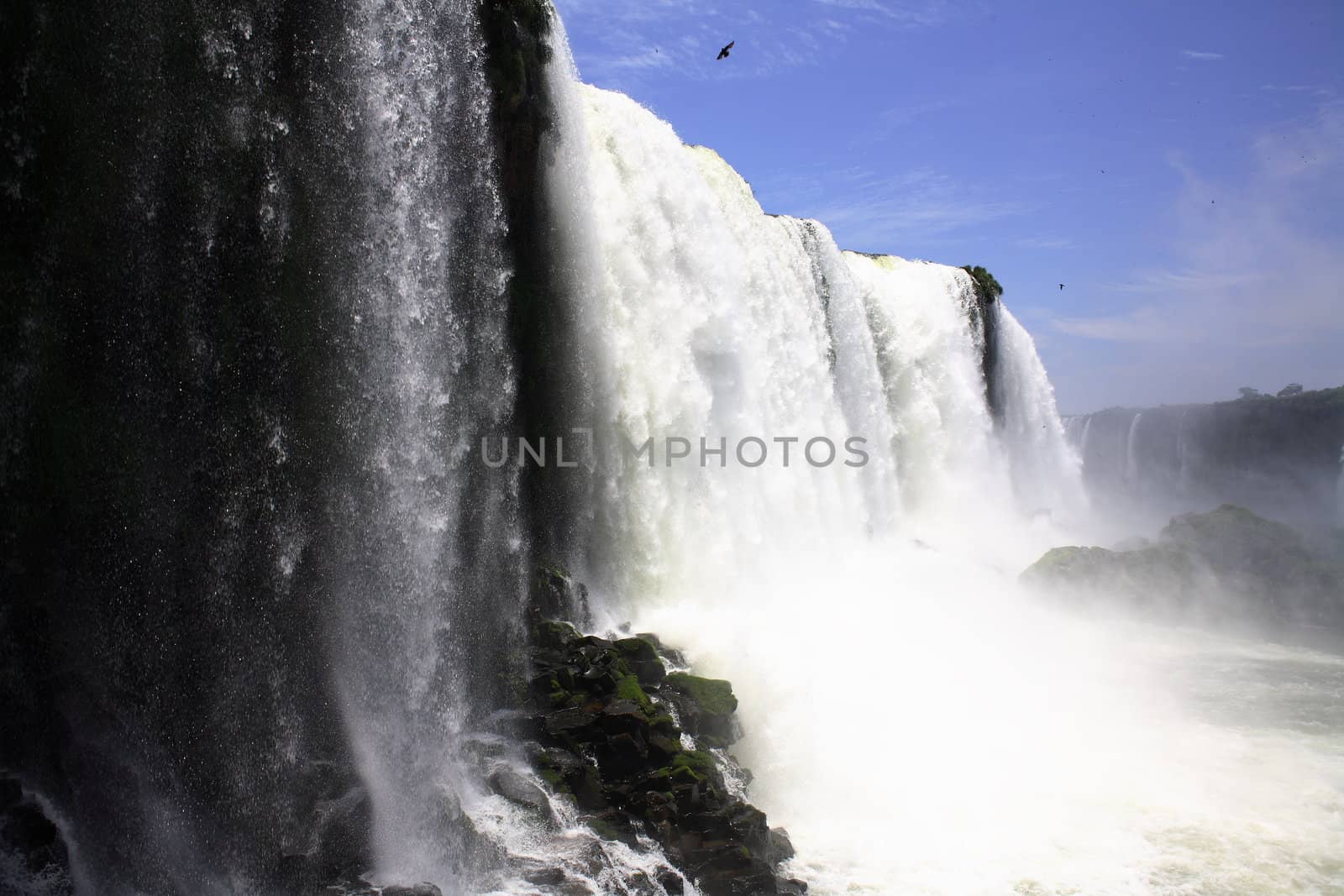 The Iguassu (or Iguazu) Falls is one of the largest masses of fresh water on the planet and divides, in South America, Brazil, Paraguay and Argentina. The waterfall system consists of 275 falls along 2.7 kilometres (1.67 miles) of the Iguazu River. Some of the individual falls are up to 82 metres (269 feet) in height, though the majority are about 64 metres (210 feet).