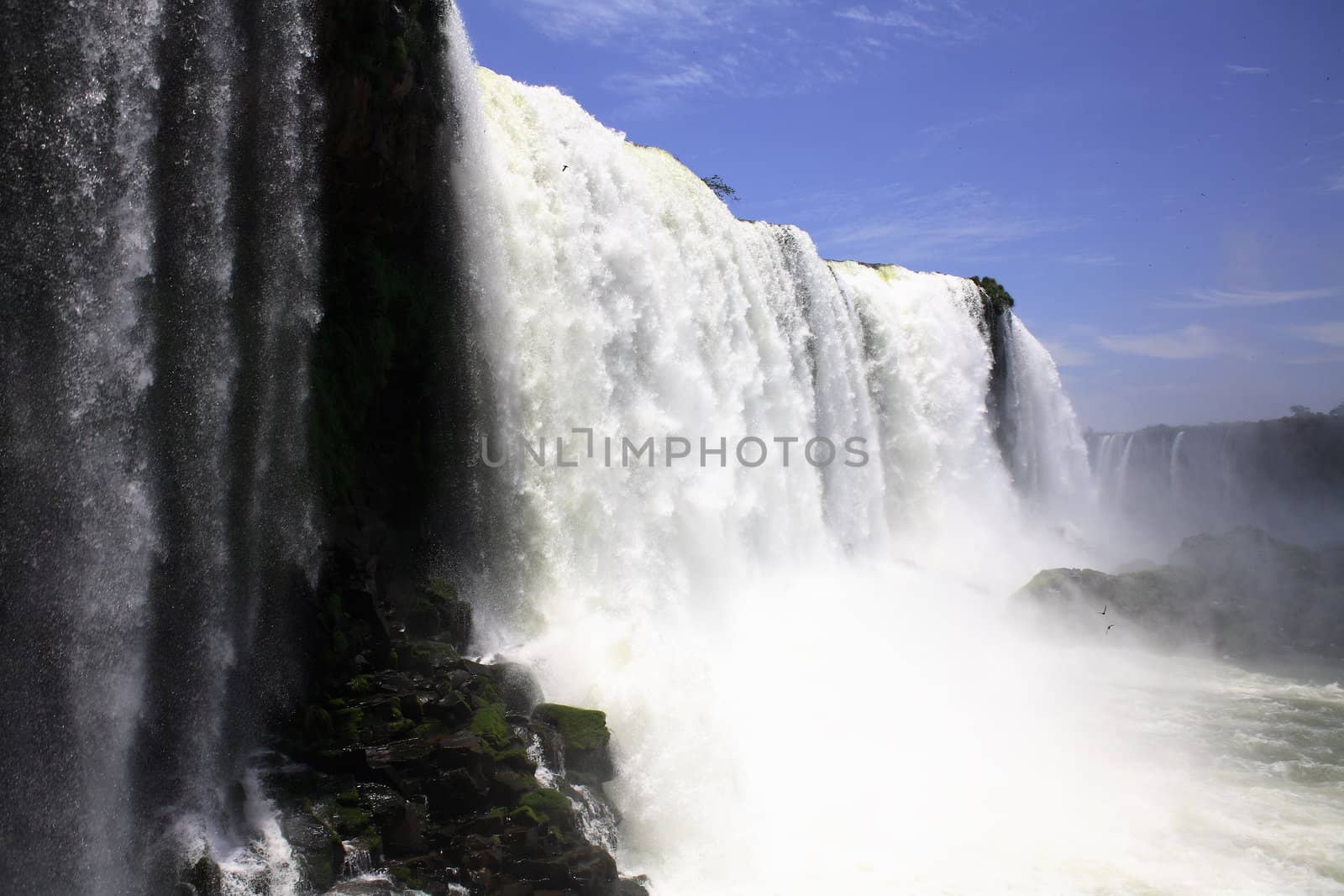 The Iguassu (or Iguazu) Falls is one of the largest masses of fresh water on the planet and divides, in South America, Brazil, Paraguay and Argentina. The waterfall system consists of 275 falls along 2.7 kilometres (1.67 miles) of the Iguazu River. Some of the individual falls are up to 82 metres (269 feet) in height, though the majority are about 64 metres (210 feet).