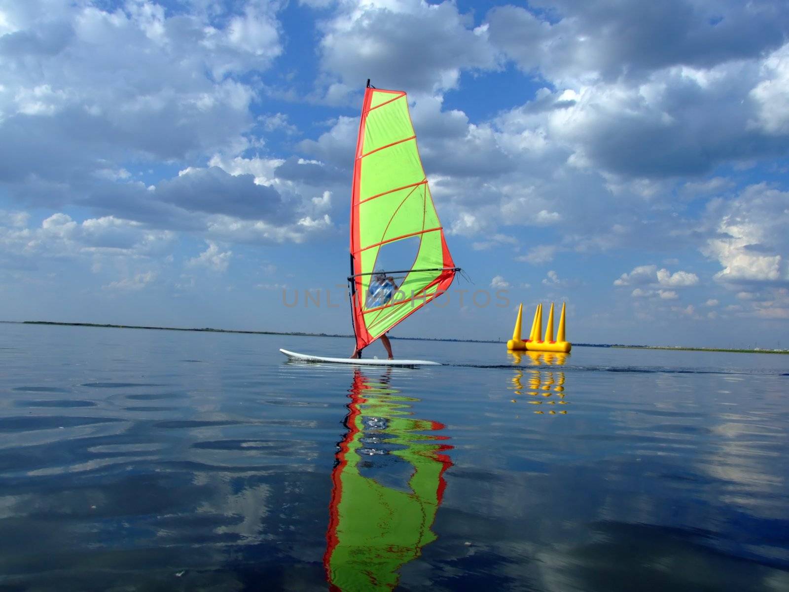 Windsurfer and its reflection in water of a gulf  by acidgrey